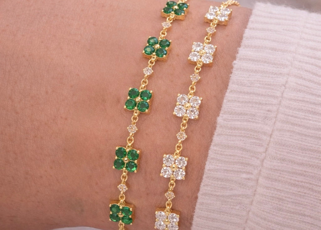 Gold bracelet with green and white gemstones on a wrist